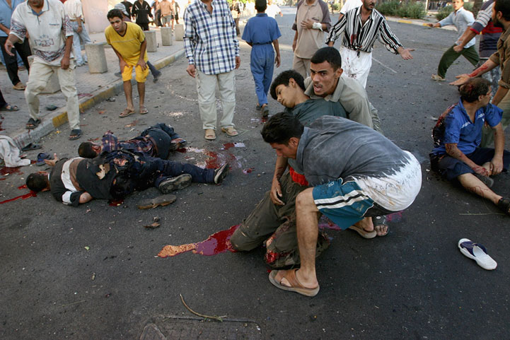 Iraqi civilians lie dying after US helicopters open fire on crowds celebrating around a burning US vehicle. Baghdad Iraq 2004.